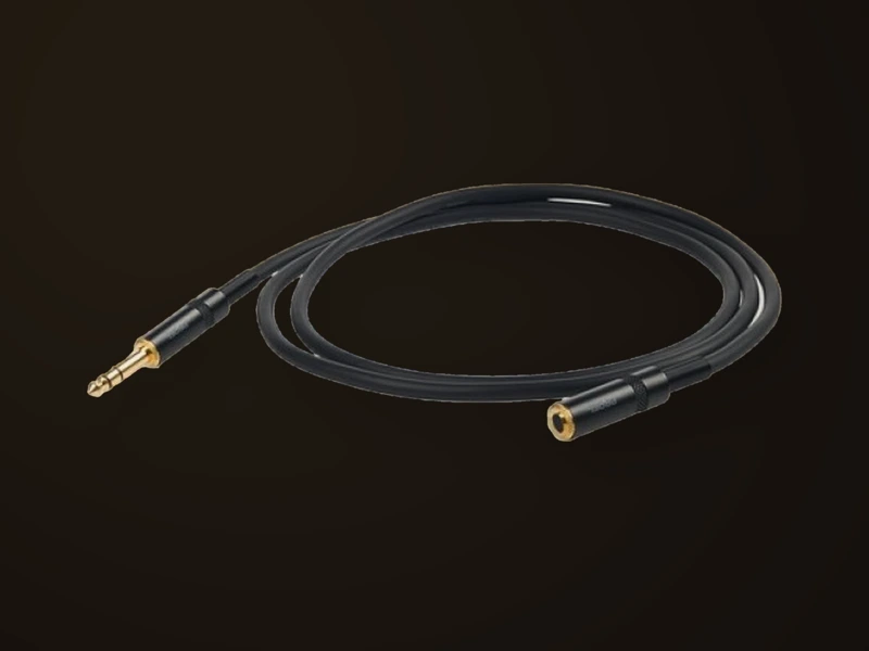 Une rallonge de jack pour casque, enroulée sur fond sombre